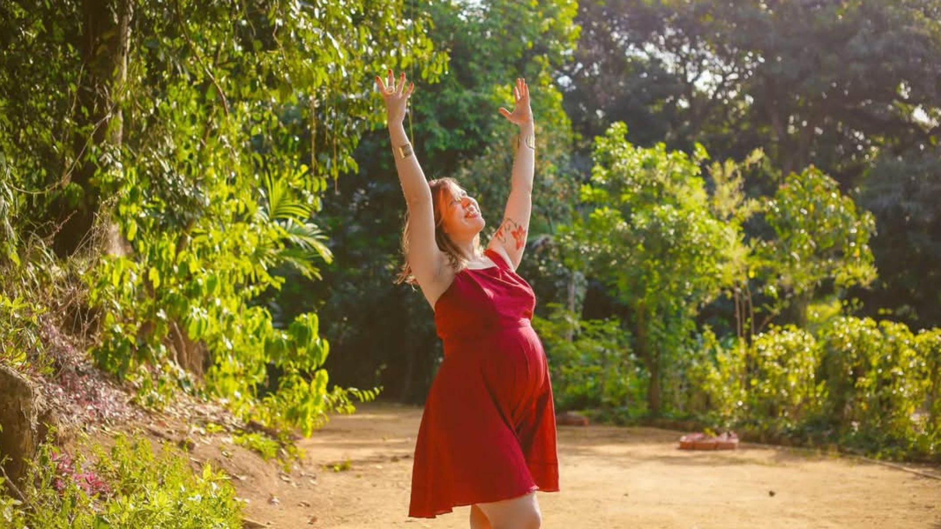 Gestante de vestido vermelho na natureza