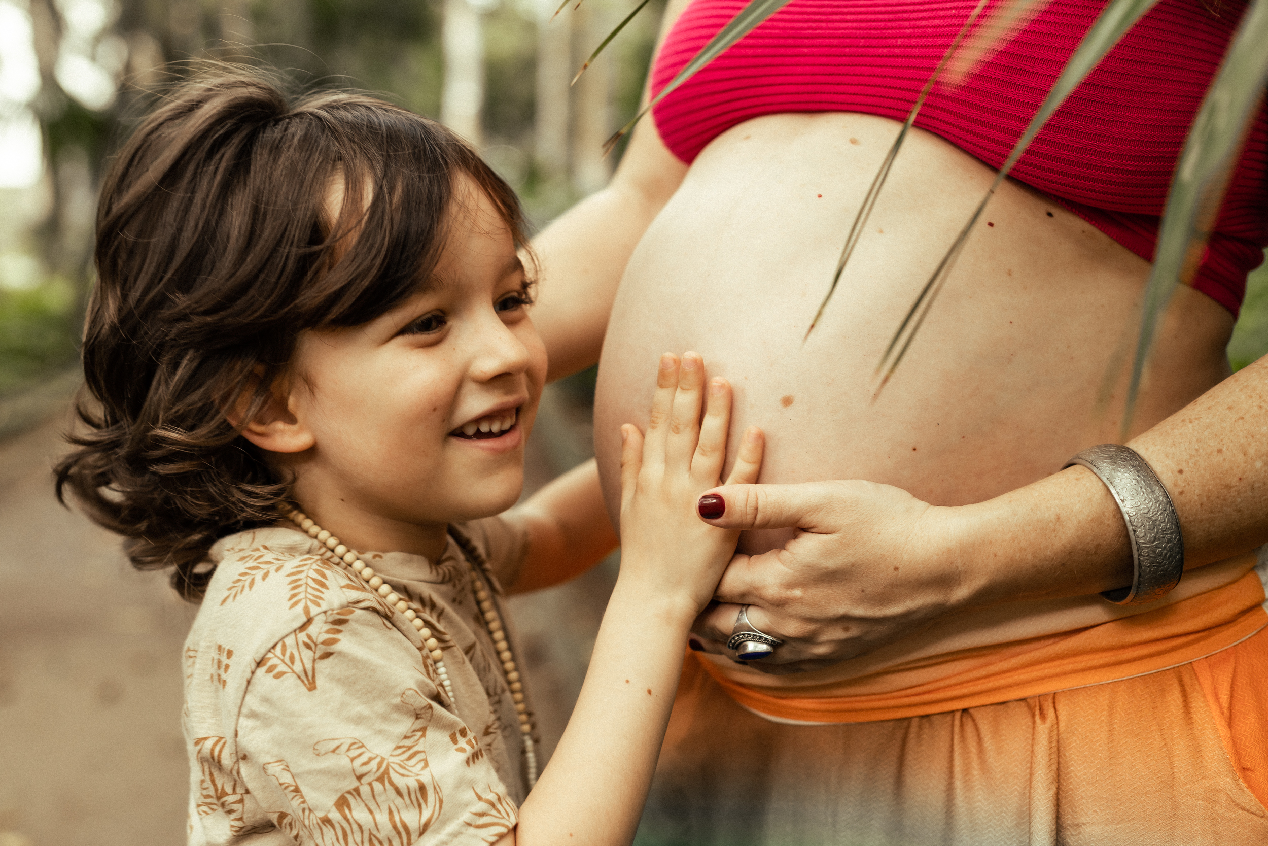 Criança tocando barriga da mãe grávida